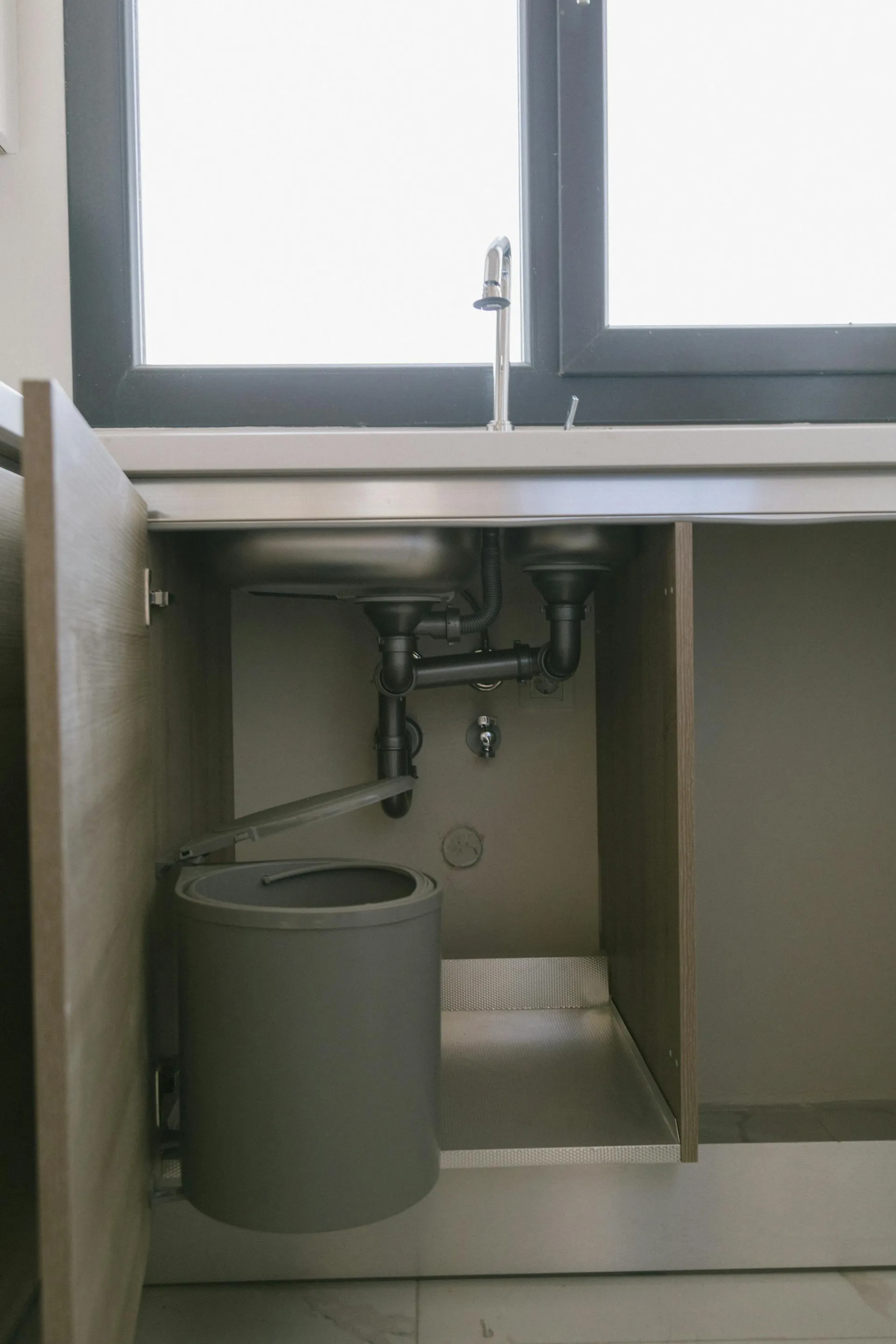 Modern under-sink kitchen plumbing fitted by JC Plumbing