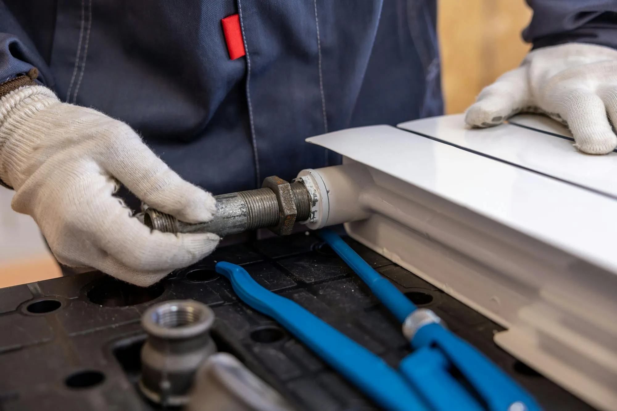 Heating engineer fitting a radiator pipe in a Dundee home